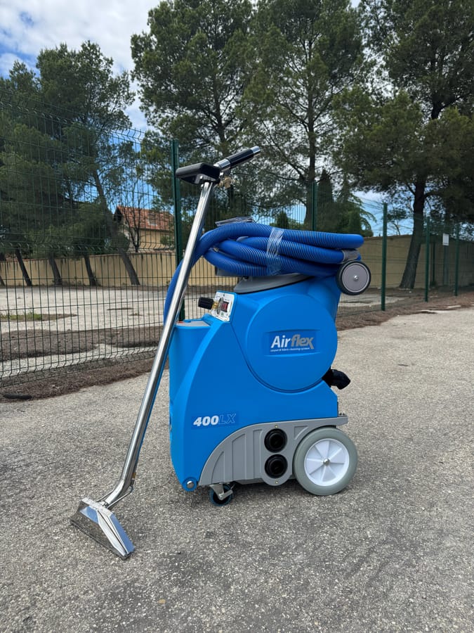 Injecteur-extracteur bleu AirFlex 400 posé seul sur un parking, suceur et flexible enroulés