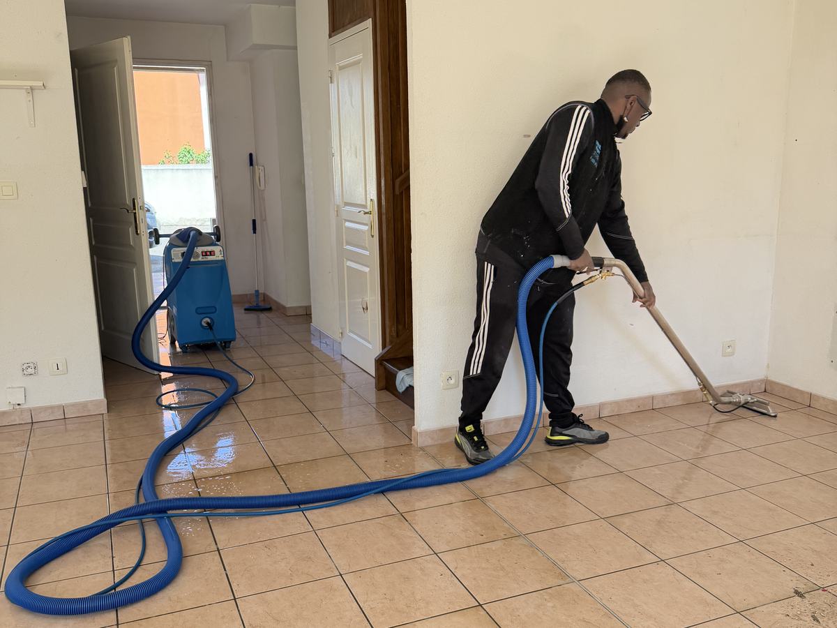 Soum passe l’injecteur-extracteur sur un sol carrelé beige dans un logement vidé