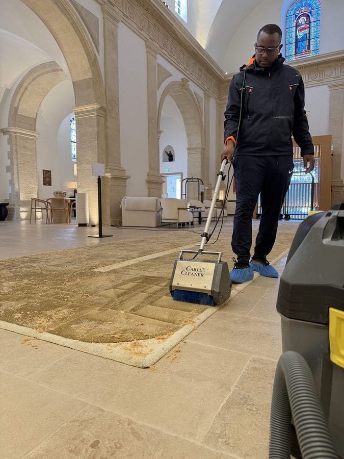 Soum conduit une autolaveuse sur le dallage clair d’une grande salle voûtée