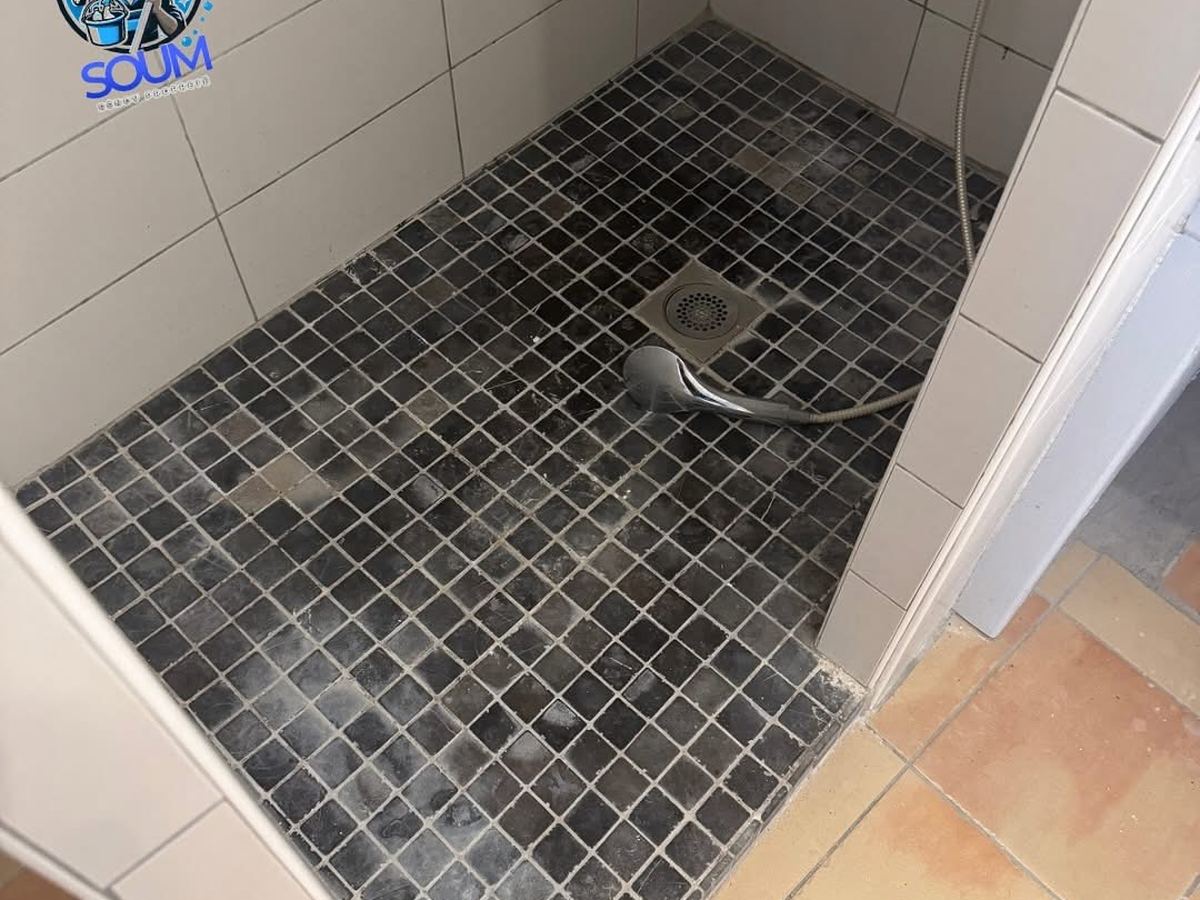 Receveur de douche en mosaïque sombre terni par le calcaire, joints grisés avant traitement