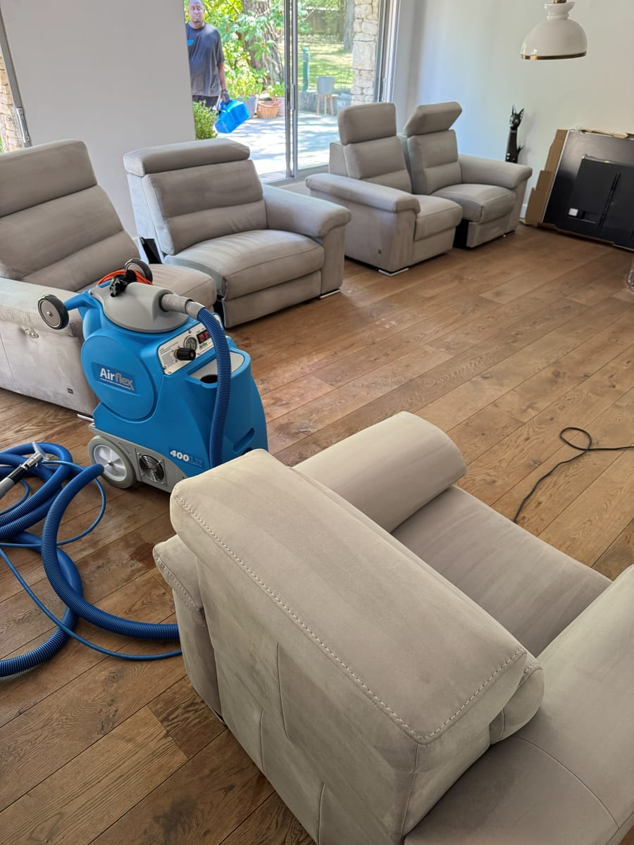 Injecteur-extracteur Airflex posé sur un parquet, au milieu de fauteuils et canapés en tissu beige
