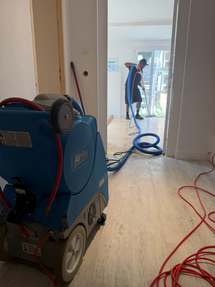 Injecteur-extracteur bleu poussé dans le couloir d'un logement, portes ouvertes de part et d'autre