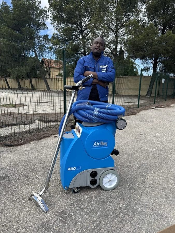 Soum se tient à côté de l'injecteur-extracteur bleu, dehors, avant une intervention