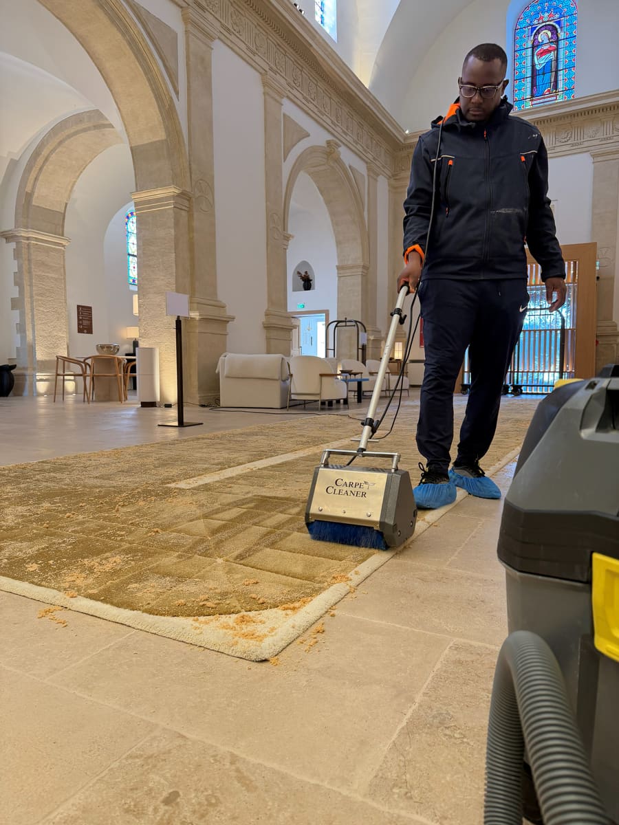 Soum traite à l'injection-extraction un grand tapis clair posé dans la nef d'une chapelle