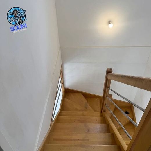 La même cage d'escalier après nettoyage, mur redevenu blanc et marches dégagées