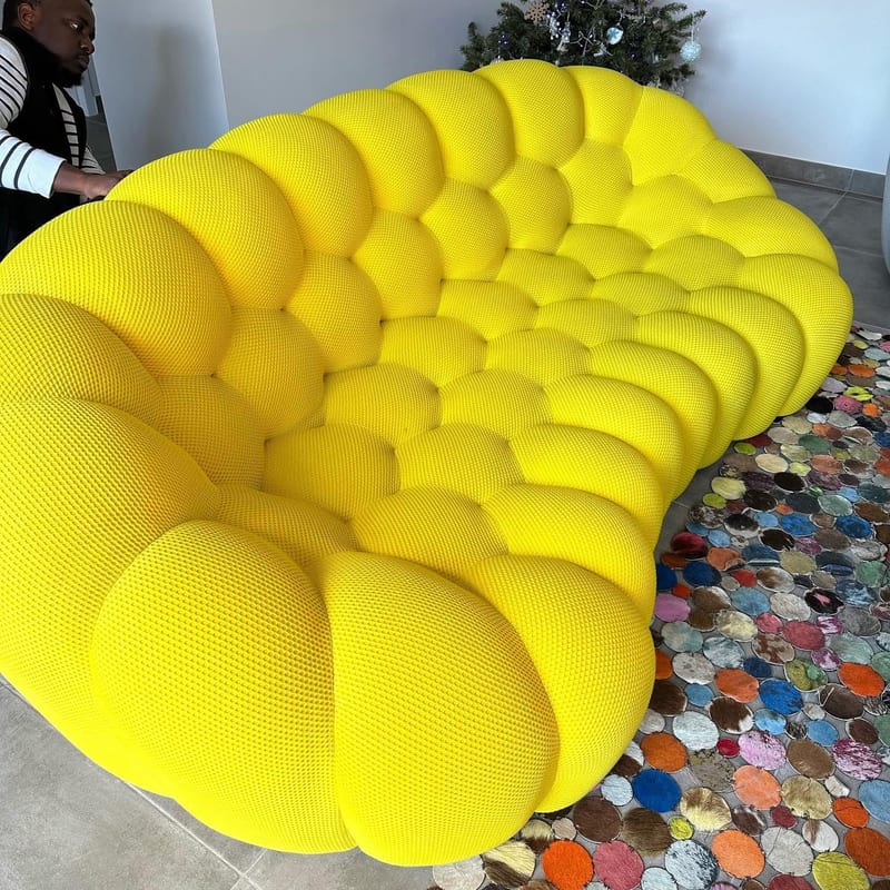 Le même canapé modulaire jaune après traitement, tissu ravivé, sur un tapis coloré