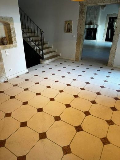 Le même sol octogonal après nettoyage, escalier de pierre visible au fond