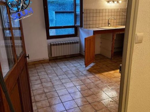 Petite cuisine vidée après intervention, sol carrelé lavé et évier dégagé