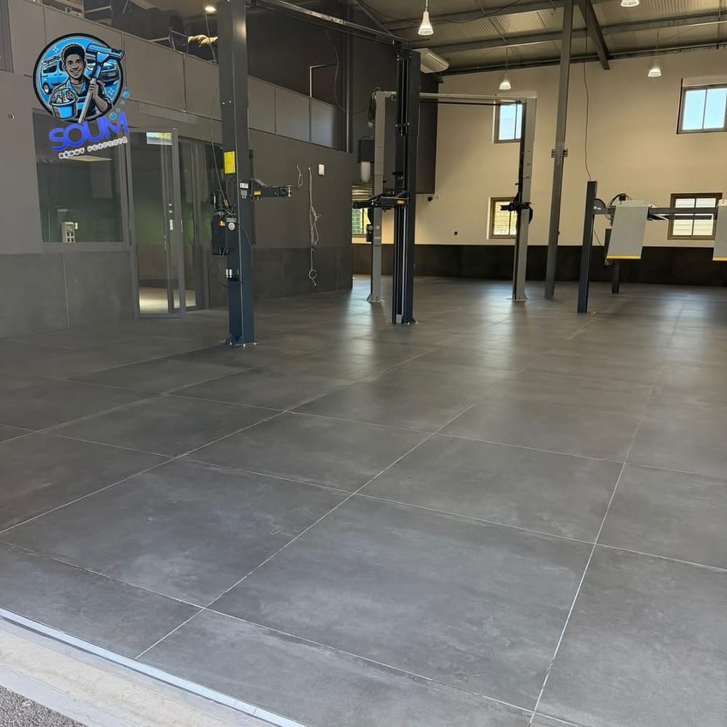 Le même sol de garage après nettoyage, carrelage gris net sous les ponts élévateurs