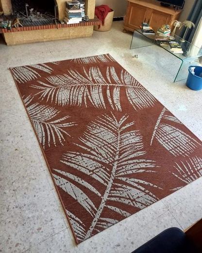 Le même tapis terracotta à motif de palmes après nettoyage, contrastes ravivés