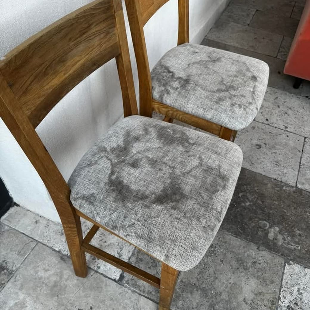 Deux chaises en bois dont les assises en tissu gris sont marquées de larges auréoles
