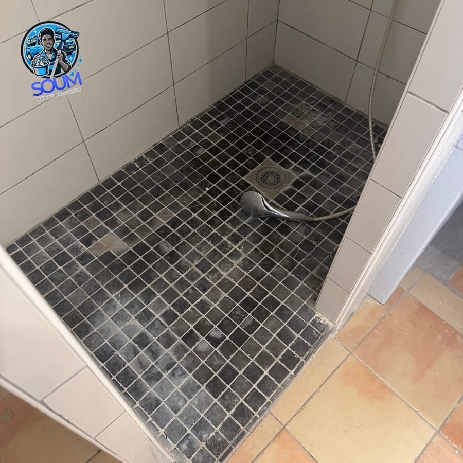 Receveur de douche en mosaïque noire terni, joints blanchis par le calcaire
