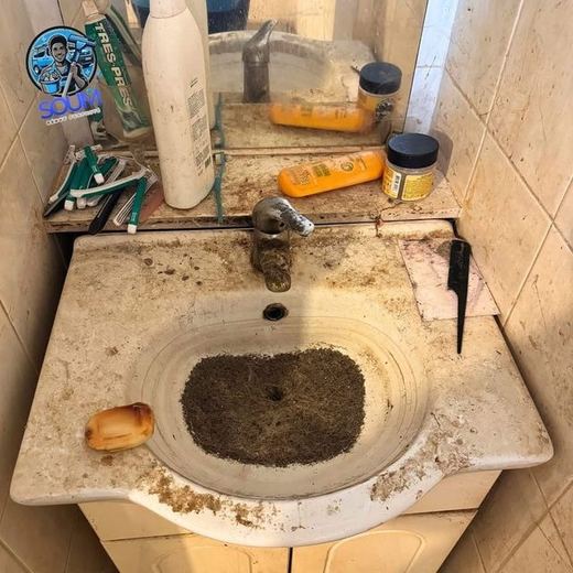 Lavabo dont la vasque et le plan sont couverts de dépôts bruns, produits entassés autour