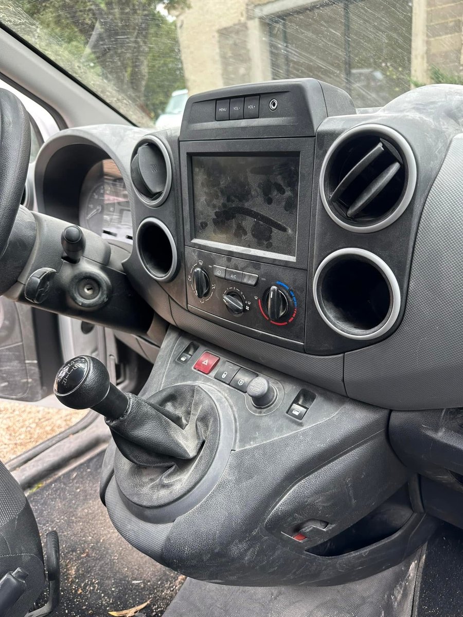 Planche de bord et console d'un utilitaire empoussiérées, écran et grilles d'aération encrassés