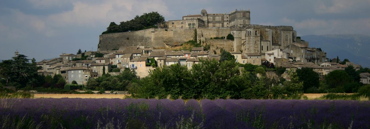 Le château de Grignan dominant les toits du village, champ de lavande au premier plan