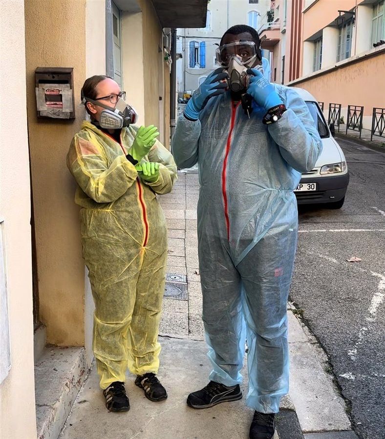 Soum et Cassandra en combinaison jetable et masque respiratoire avant une intervention