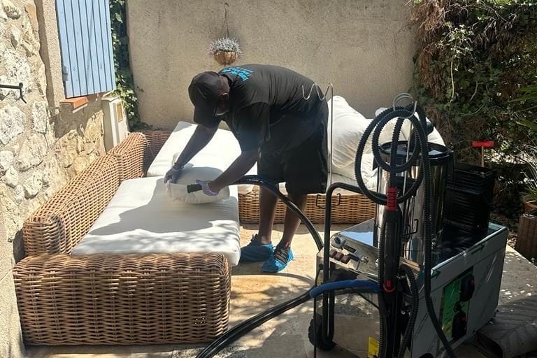 Soum traite au nettoyeur vapeur l'assise d'un canapé de jardin en résine tressée